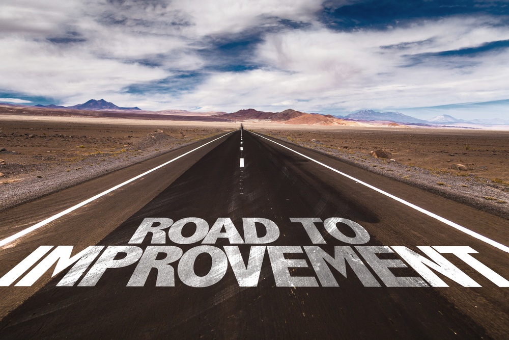 Road To Improvement Written On Desert Road